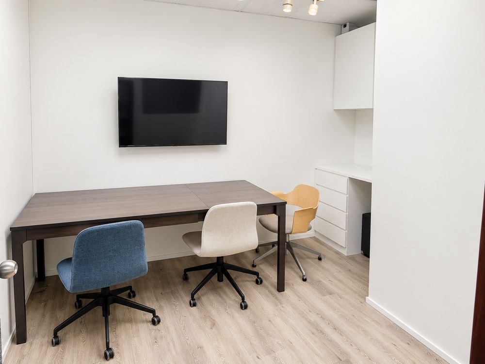 Private 1-to-1 lesson room with a table, three chairs and a wall-mounted screen