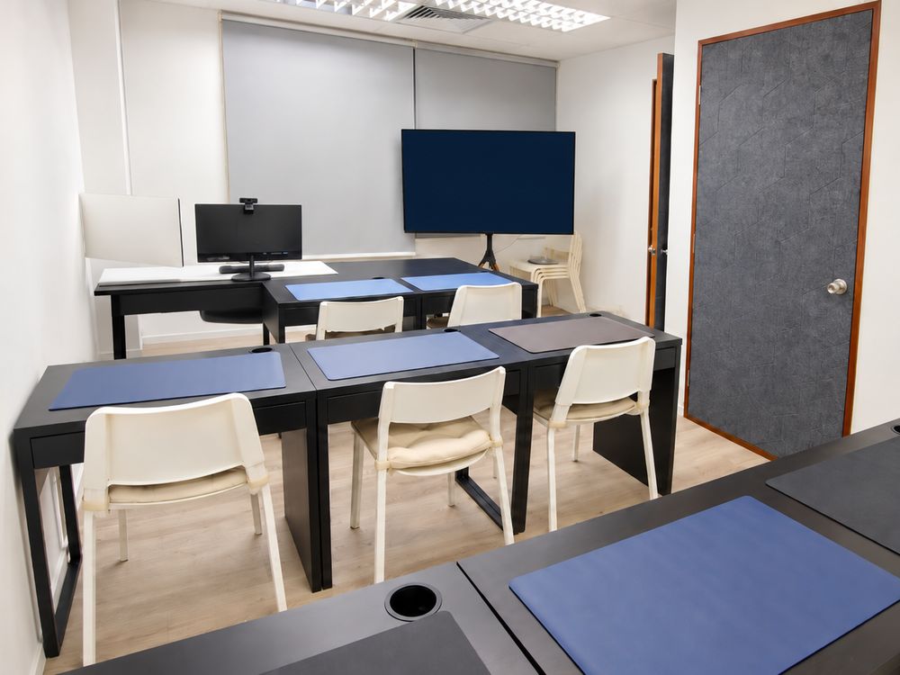 Small-group classroom at Starhill Education with dark desks and white chairs